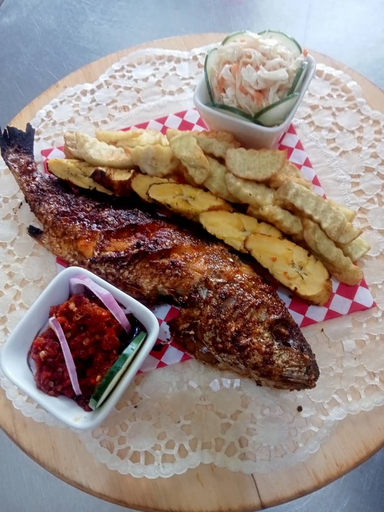 Full grilled fish with sauce, paired with plantain or Irish